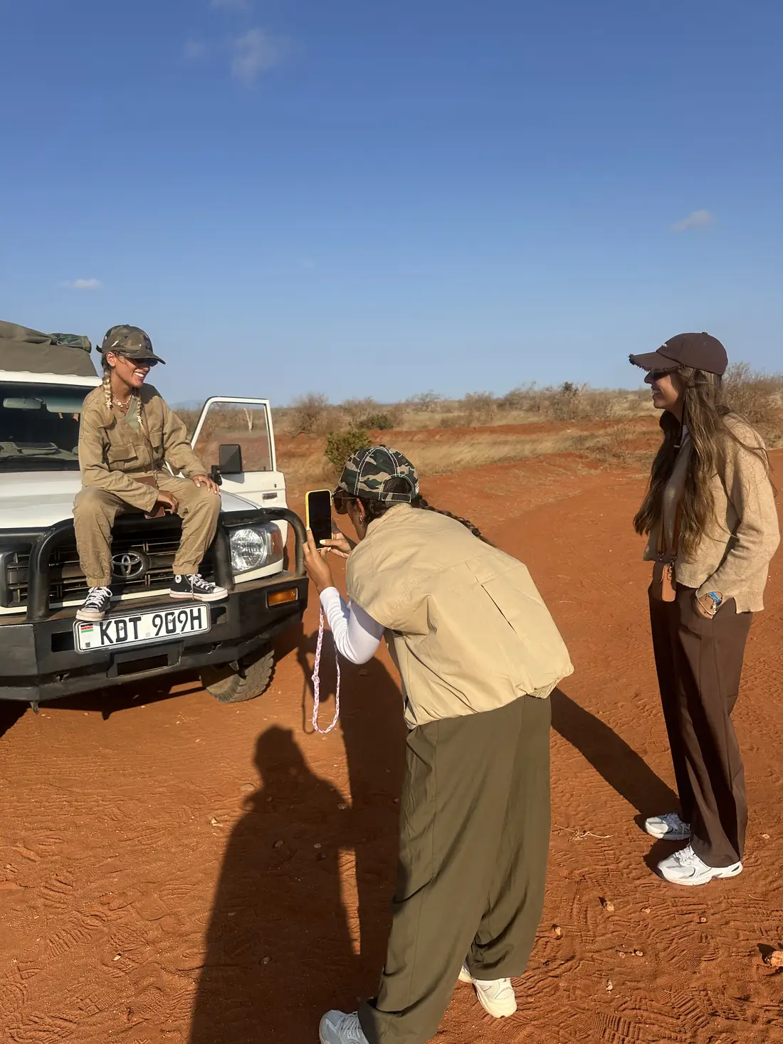 Viaggiatori accanto alla jeep sulla terra rossa dello Tsavo Est